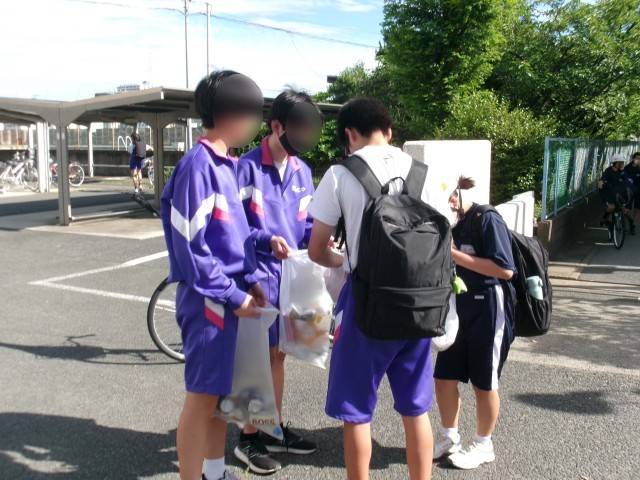 登校中に袋一杯のゴミを集める生徒達